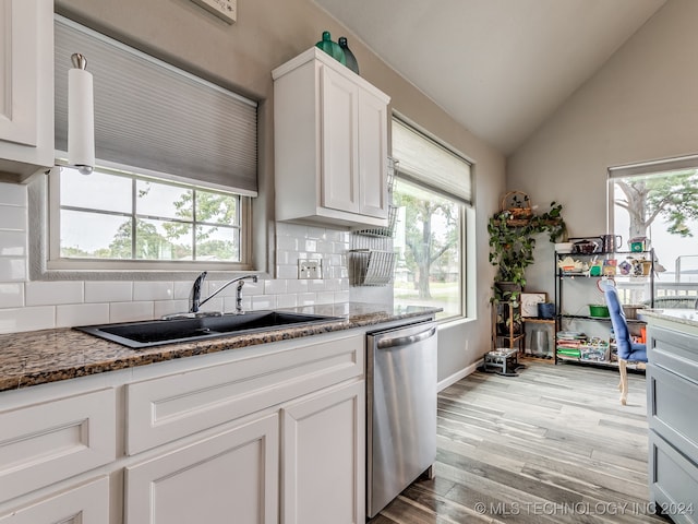 kitchen featuring sink, dishwasher, white cabinetry, light hardwood / wood-style floors, and dark stone counters