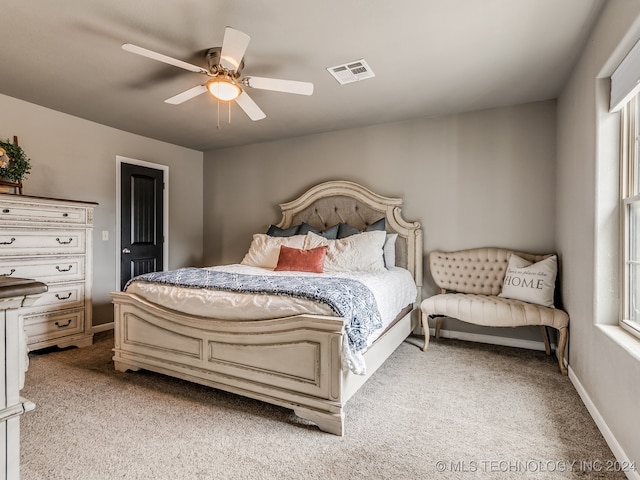 bedroom featuring multiple windows, light colored carpet, and ceiling fan