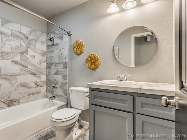 full bathroom featuring vanity, tiled shower / bath, and toilet