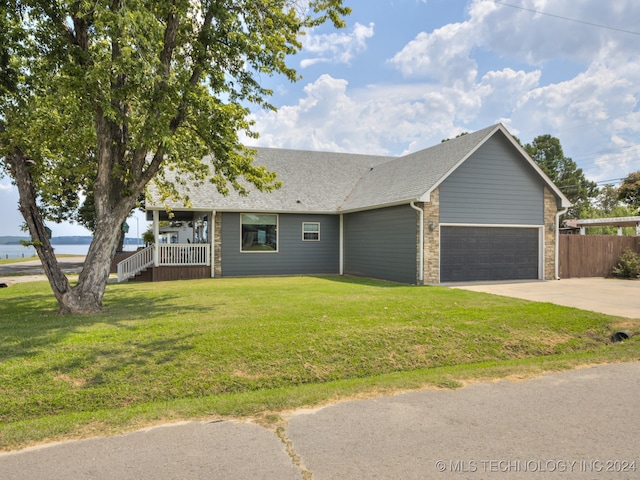 ranch-style home with covered porch, a garage, and a front lawn