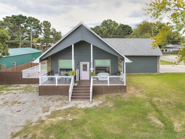 view of front of property featuring a front lawn and a wooden deck