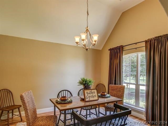 dining room featuring lofted ceiling, hardwood / wood-style floors, and an inviting chandelier