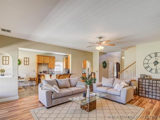 living room with light hardwood / wood-style flooring and ceiling fan