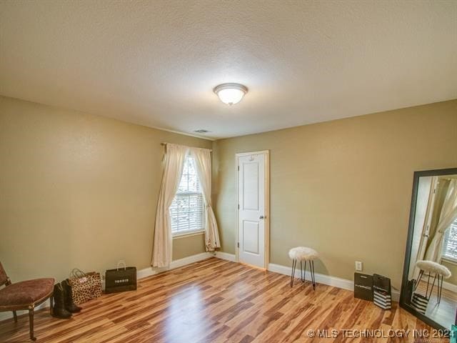 interior space featuring a textured ceiling and hardwood / wood-style floors