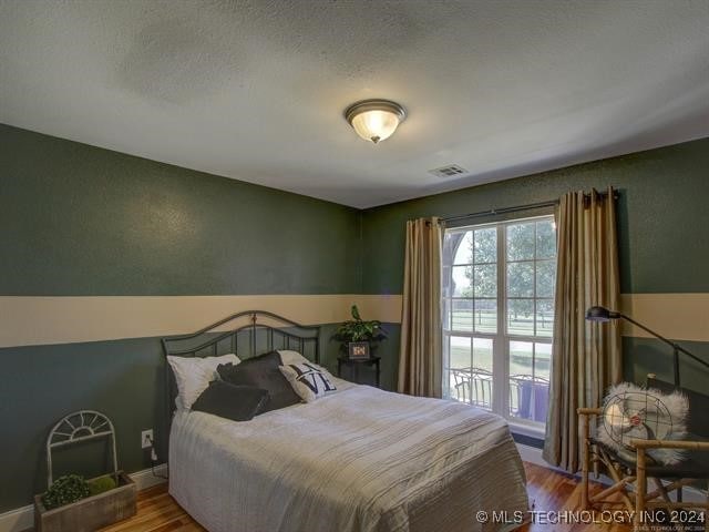 bedroom featuring wood-type flooring and a textured ceiling