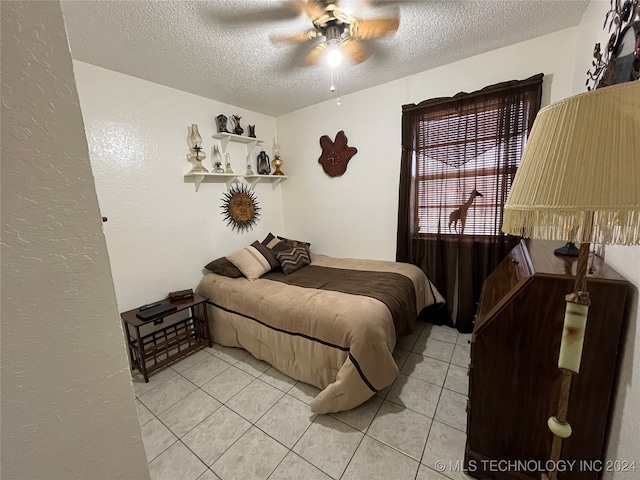 bedroom with a textured ceiling, ceiling fan, and light tile patterned floors