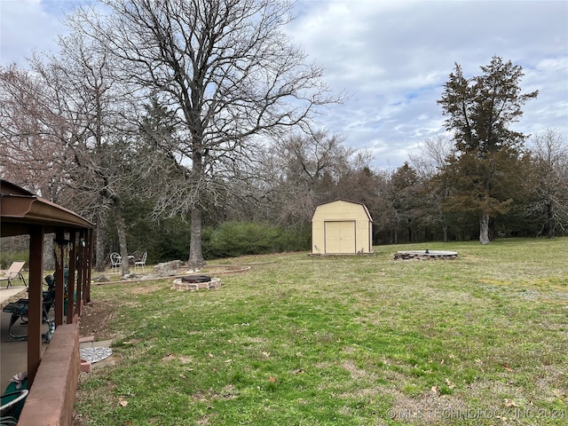 view of yard with a shed and an outdoor fire pit