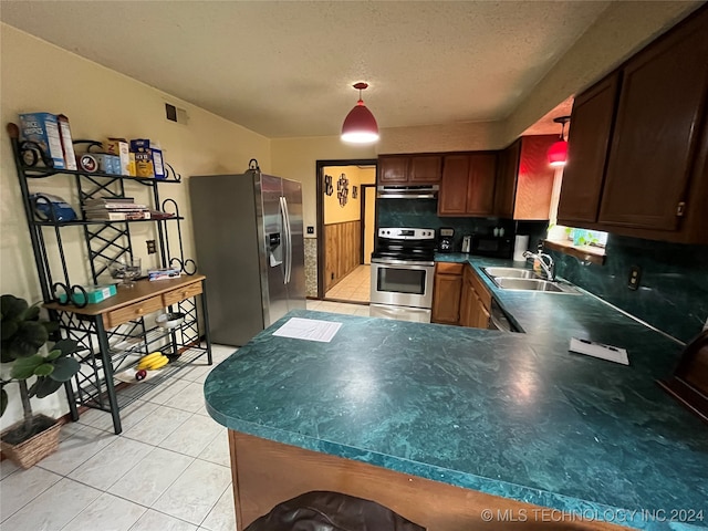 kitchen featuring hanging light fixtures, appliances with stainless steel finishes, sink, tasteful backsplash, and a textured ceiling