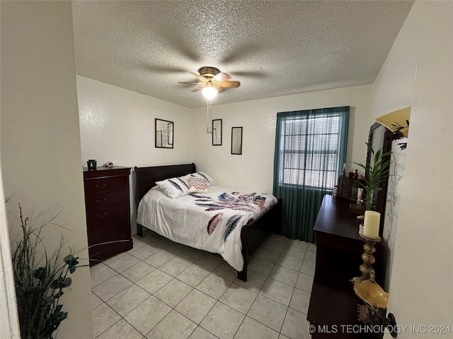 tiled bedroom with ceiling fan and a textured ceiling