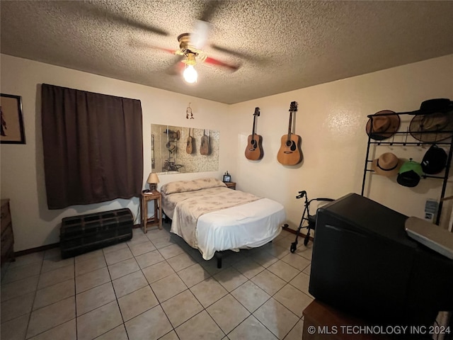 tiled bedroom featuring ceiling fan and a textured ceiling