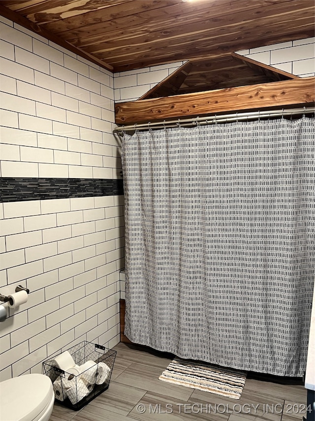 bathroom featuring tile walls, toilet, hardwood / wood-style floors, and wooden ceiling