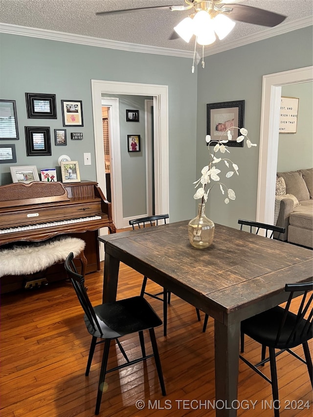 dining area with a textured ceiling, crown molding, ceiling fan, and dark hardwood / wood-style floors