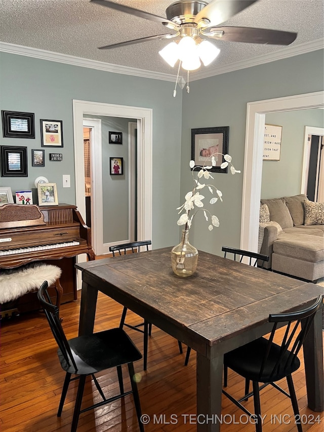 dining room featuring ceiling fan, dark hardwood / wood-style floors, crown molding, and a textured ceiling