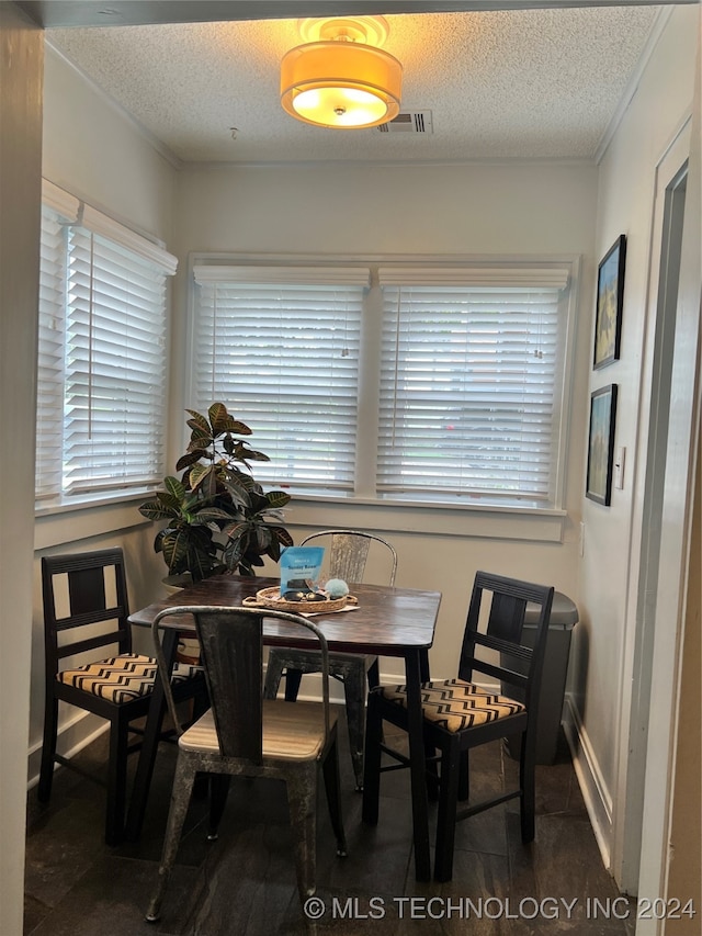 dining room featuring crown molding and a textured ceiling