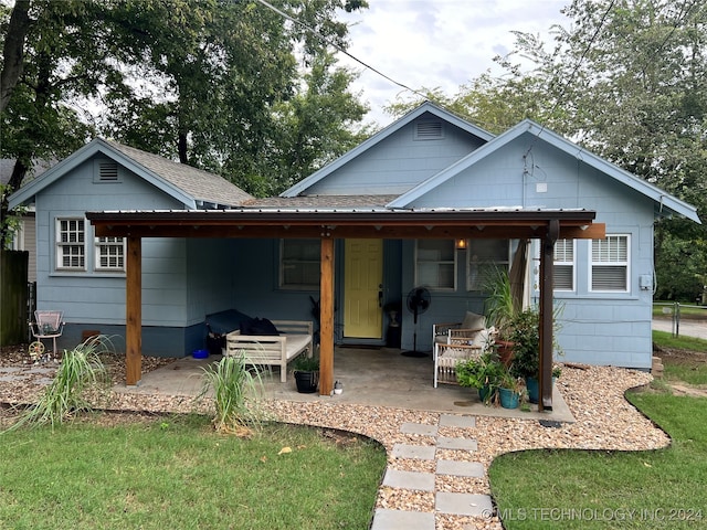 back of house featuring a lawn and a patio area