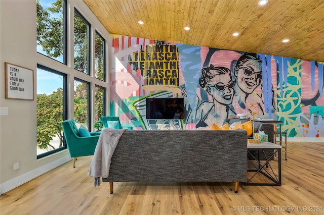 living area featuring hardwood / wood-style floors, a towering ceiling, and wooden ceiling