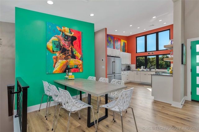 dining space with a high ceiling and light wood-type flooring