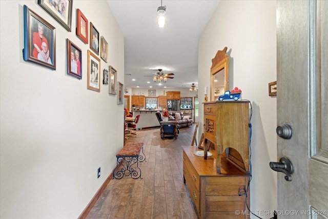 hallway with baseboards and hardwood / wood-style floors