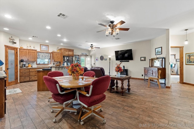 dining space with light wood-type flooring and ceiling fan