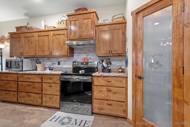 kitchen featuring light stone countertops, stainless steel appliances, and tasteful backsplash