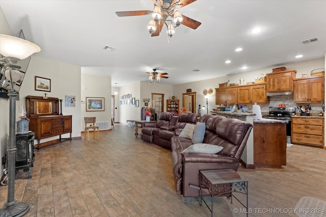 living room with ceiling fan and light hardwood / wood-style floors