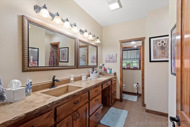 full bathroom featuring tile patterned floors, toilet, a sink, double vanity, and baseboards