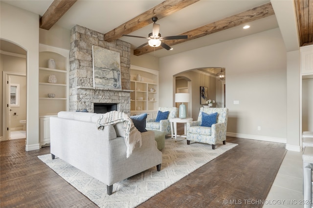 living room featuring built in features, ceiling fan, a fireplace, and beamed ceiling