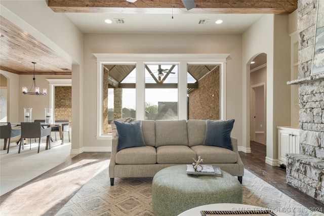 tiled living room featuring ceiling fan with notable chandelier