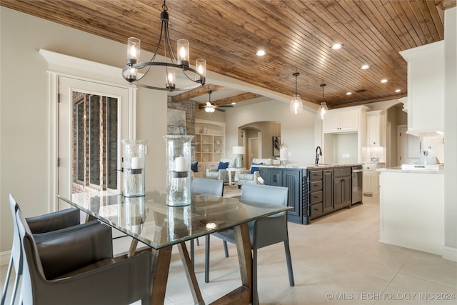 tiled dining area with ceiling fan with notable chandelier, beam ceiling, sink, and wooden ceiling