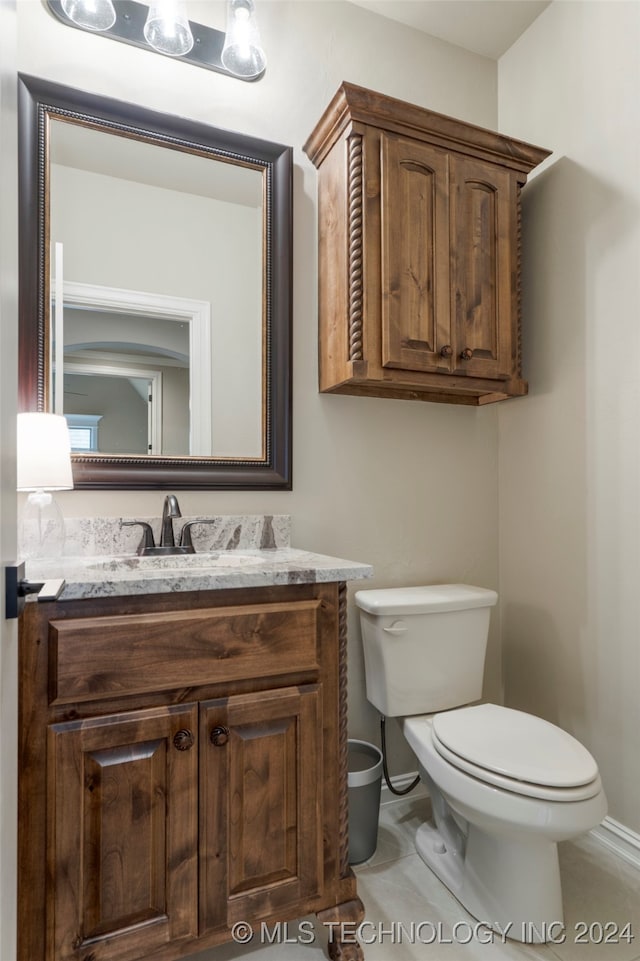 bathroom featuring vanity, toilet, and tile patterned flooring