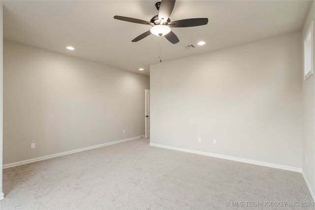 empty room featuring ceiling fan and light colored carpet