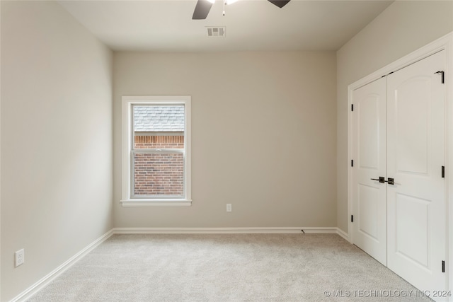 unfurnished bedroom featuring a closet, ceiling fan, and light carpet