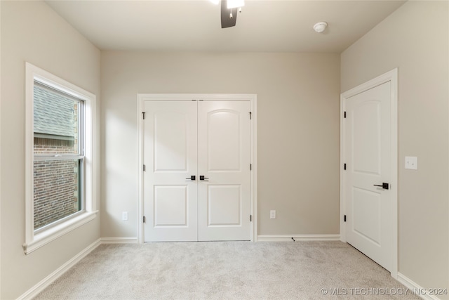 unfurnished bedroom featuring a closet, ceiling fan, and light carpet