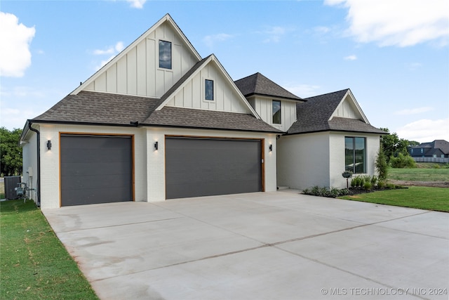 view of front of home with a garage, a front lawn, and central air condition unit