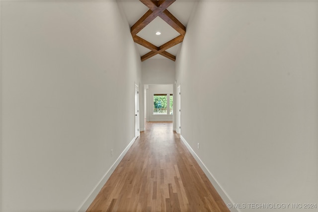 hall featuring coffered ceiling, light hardwood / wood-style flooring, and beam ceiling