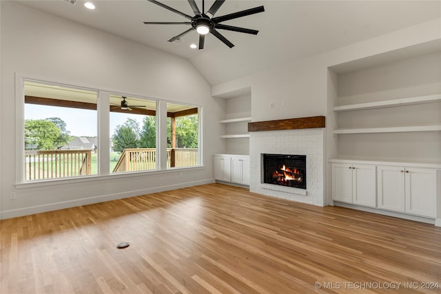 unfurnished living room featuring a fireplace, light hardwood / wood-style flooring, built in shelves, and ceiling fan