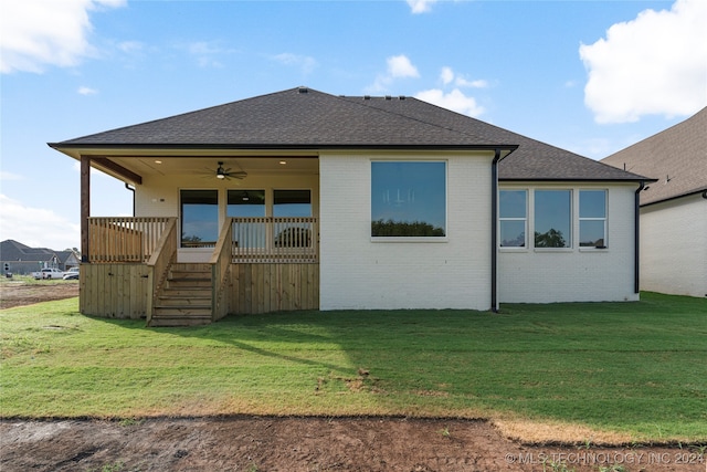 rear view of house with a wooden deck, a lawn, and ceiling fan