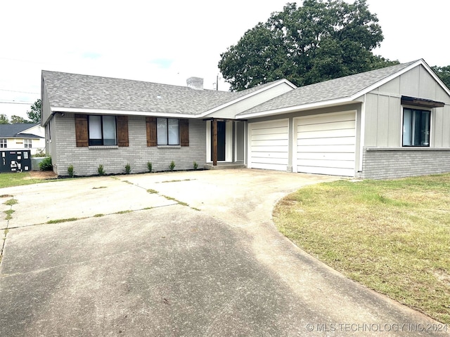 single story home with a garage and a front lawn