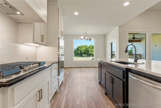 kitchen featuring appliances with stainless steel finishes, light hardwood / wood-style floors, white cabinetry, and sink