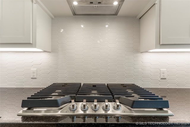 room details with white cabinetry, stainless steel gas stovetop, range hood, and tasteful backsplash