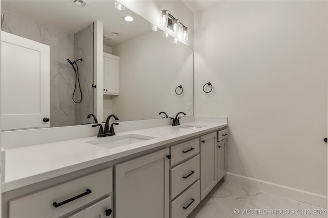 bathroom featuring tiled shower and vanity