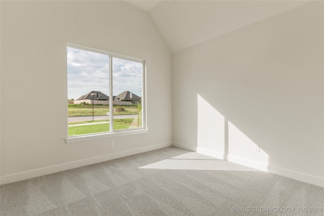 empty room featuring light carpet and lofted ceiling