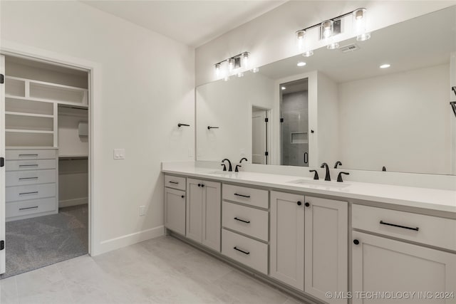 bathroom featuring a shower with door and vanity