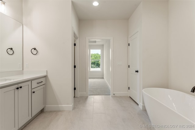 bathroom featuring vanity, a bathtub, and tile patterned floors