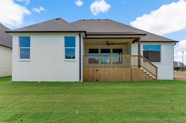 rear view of house featuring a yard and ceiling fan