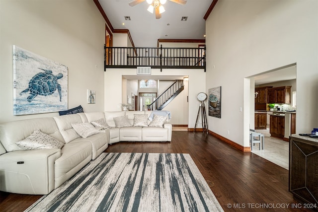 living room with dark hardwood / wood-style flooring, a high ceiling, and ceiling fan