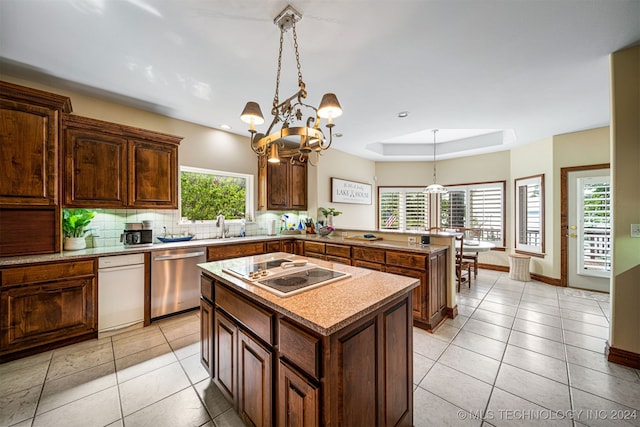 kitchen featuring backsplash, a center island, an inviting chandelier, appliances with stainless steel finishes, and pendant lighting