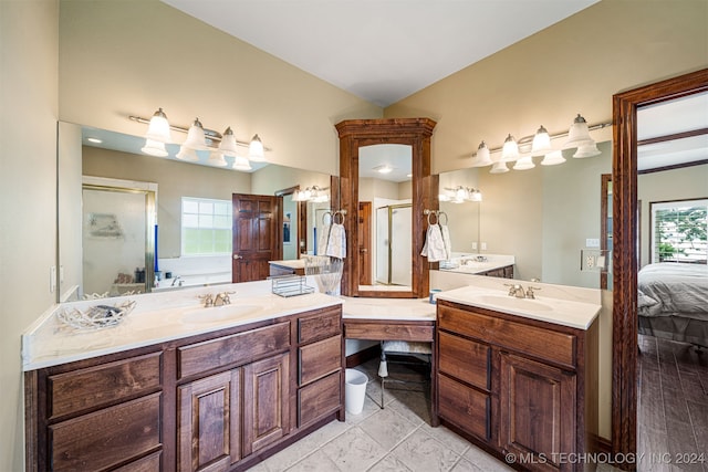 bathroom featuring plenty of natural light, vanity, wood-type flooring, and plus walk in shower