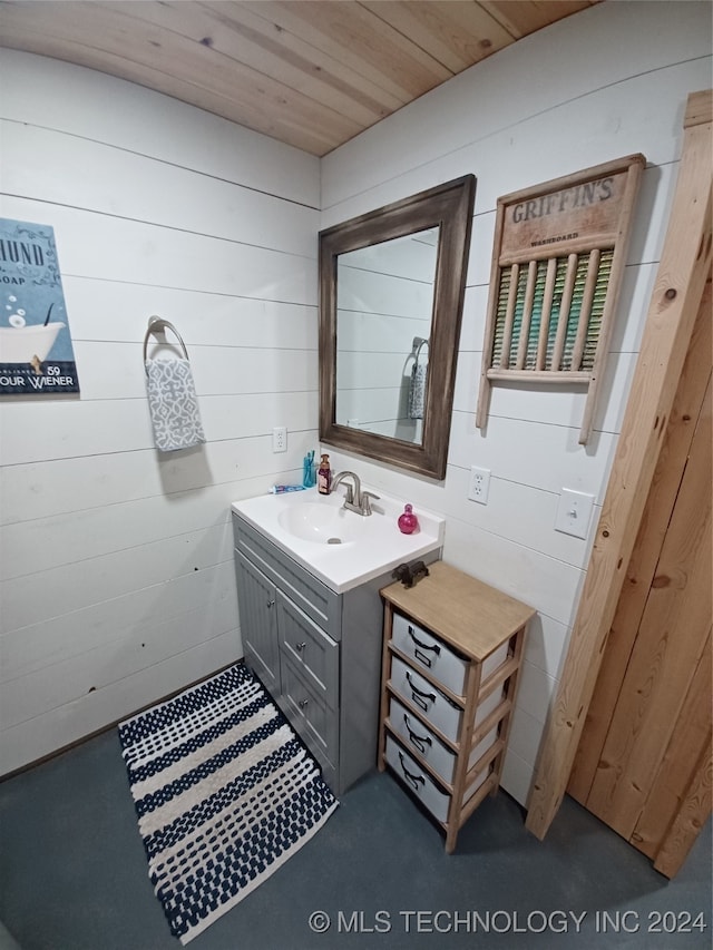 bathroom featuring wood ceiling, vanity, and wood walls