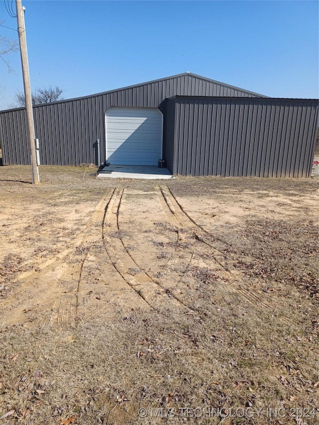 view of yard featuring a garage and an outbuilding